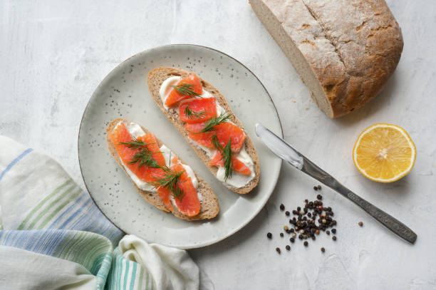 istock Two toast with smoked salmon, cream cheese and dill on rustic plate. 873134226
