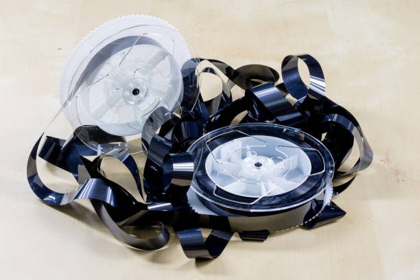 istock Image on video tape. Videotape tape wound on spools. Wooden table, black background. 873134334