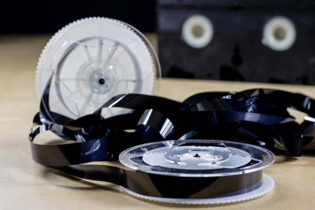 istock Image on video tape. Videotape tape wound on spools. Wooden table, black background. 873137014
