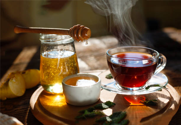 gesundes frühstück. teetrinken. morgen zeit. eine tasse schwarzen tee, honig, minze blätter, äpfel. - mint tea lemon tea leaves glass stock-fotos und bilder