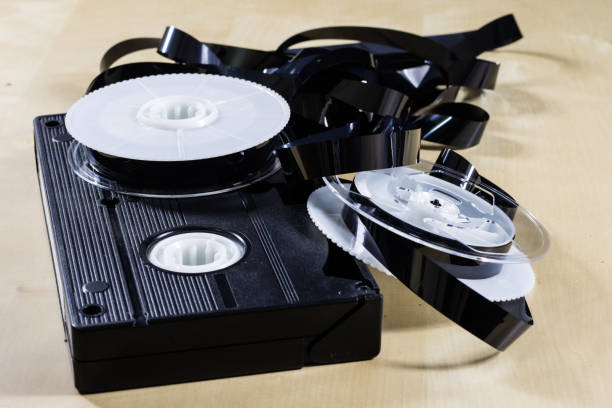 istock Image on video tape. Videotape tape wound on spools. Wooden table, black background. 873137894