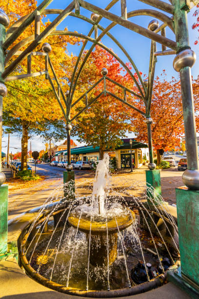 Beautiful tiered fountain against blue sky. Two tiered blue and gray fountain with intricate design against a blue sky. Beads of sparkling clear water trickle down from the top basin to the bottom.