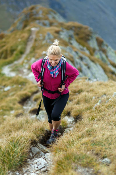 istock Woman with backpack hiking on a trail 873141996