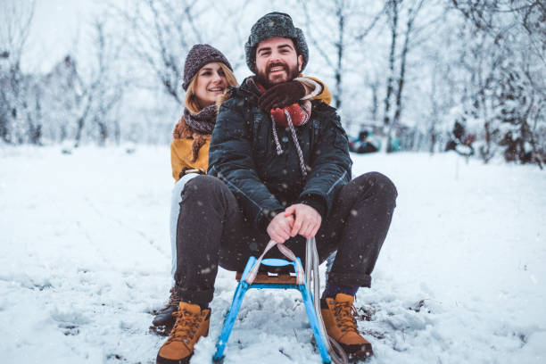 istock Beautiful young couple enjoying sledding in the mountain 873145852