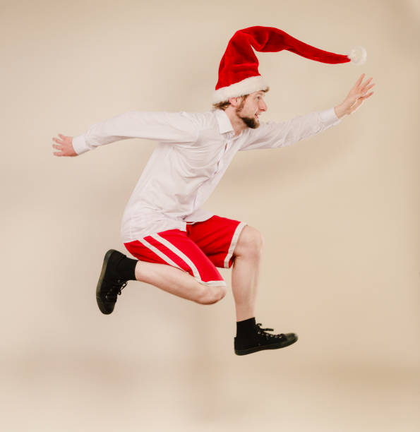 istock Active man in santa hat dancing and jumping. 873152538
