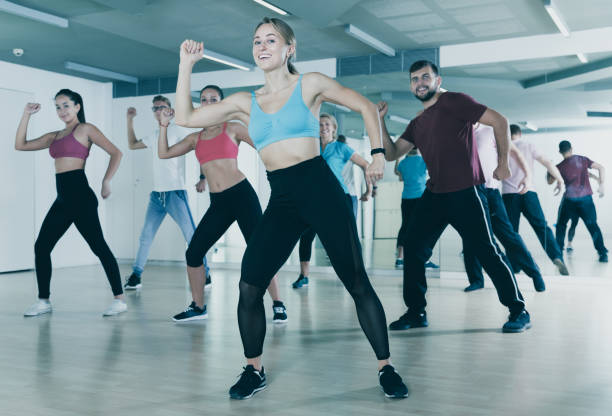 People training at dance class Happy people of different ages studying zumba dance elements in dancing hall curtseying stock pictures, royalty-free photos & images