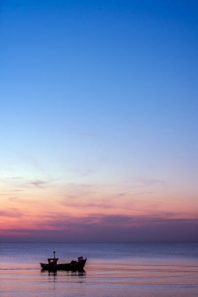 istock Small fisherman boat sailing at dusk 873157102