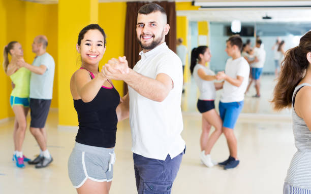 istock sporty girls and men learning salsa steps 873164440