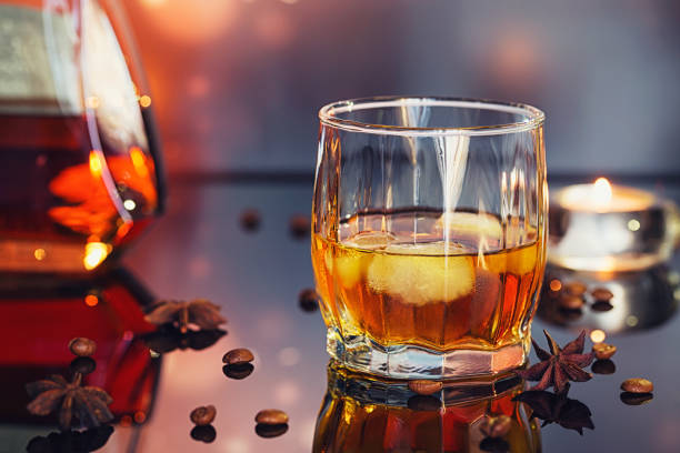 istock Cognac or liqueur, coffee beans and spices on a glass table. 873164648