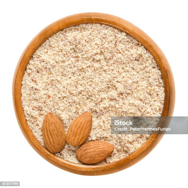 Frutos Secos Almendra Sin Cáscara Y Molidas En Madera Del Tazón De Fuente Sobre Blanco Foto de stock y más banco de imágenes de Almendra