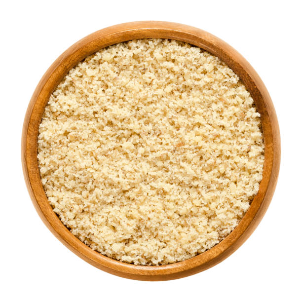 istock Ground walnuts in wooden bowl over white 873177228