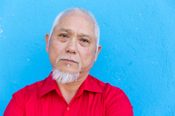istock Mature asian man on blue background 873179692
