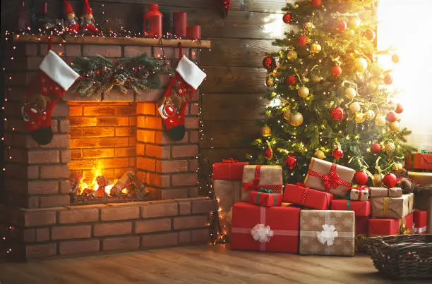 Photo of interior christmas. magic glowing tree, fireplace, gifts