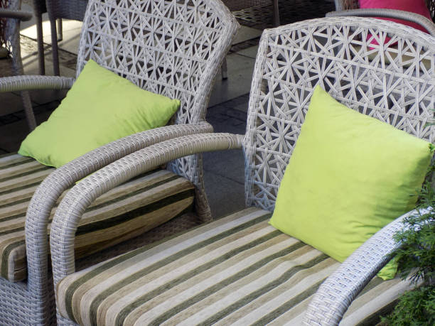 istock White rattan chairs with a green and stripped cushions 873184546