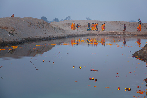 Ceremony candle of the water with women in orange dress on the background. Vrindavan, India