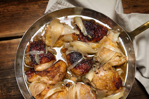 istock Braised chicken with onions and wine in a copper pan 873191762