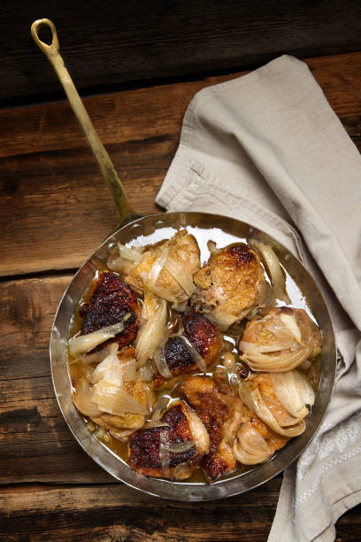 istock Braised chicken with onions and wine in a copper pan 873192132
