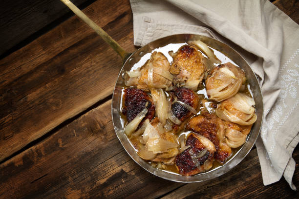 istock Braised chicken with onions and wine in a copper pan 873192138