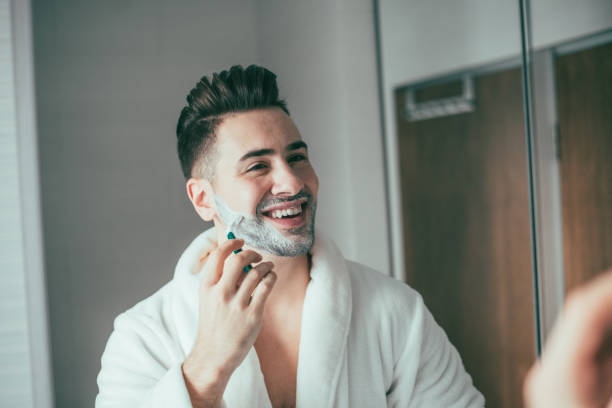 istock Man shaving his beard in front of a mirror 873192890