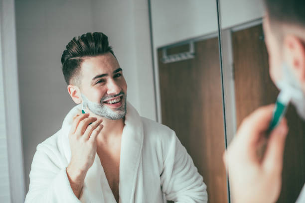 istock Man in the bathroom shaving his beard 873192902