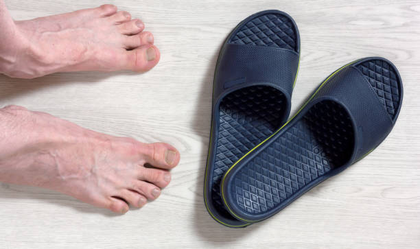 Male Bare Feet and a Pair of Flip Flops stock photo