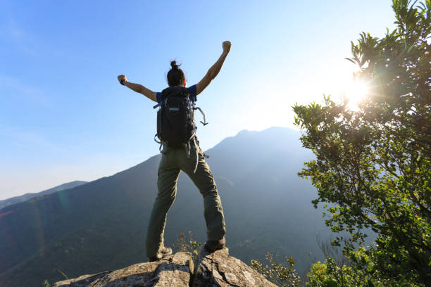 istock successful young woman enjoy the view on cliff's edge 873199716