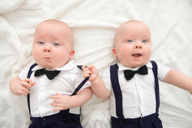идентичные близнецы в смокинге - babies and children close up horizontal looking at camera стоковые фото и изображения
