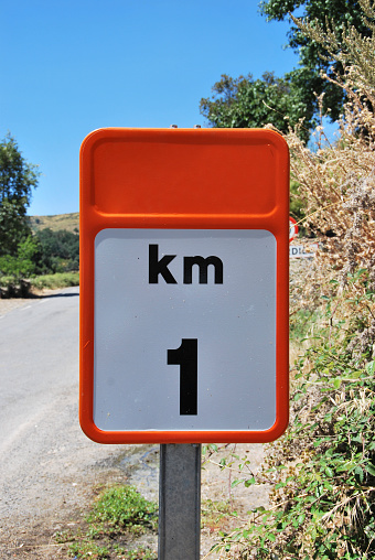 Traffic sign that indicates one kilometer distance from here