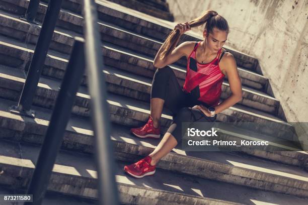 Mujeres De Deporte Sonriente Jugando Con Su Cola De Caballo En Escalera Foto de stock y más banco de imágenes de Deporte