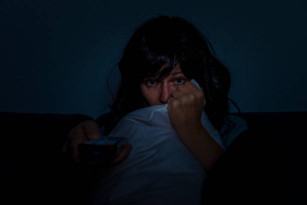 istock afraid woman with television remote control hiding face 873211736