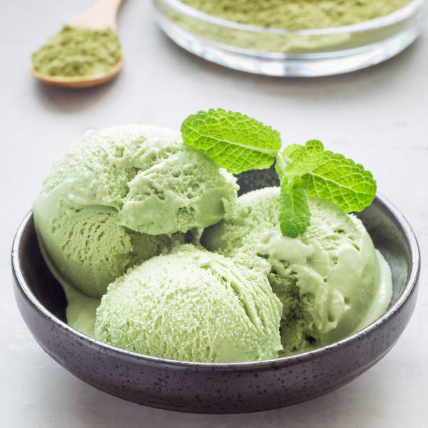 istock Matcha green tea ice cream balls in a black bowl, square format 873212178