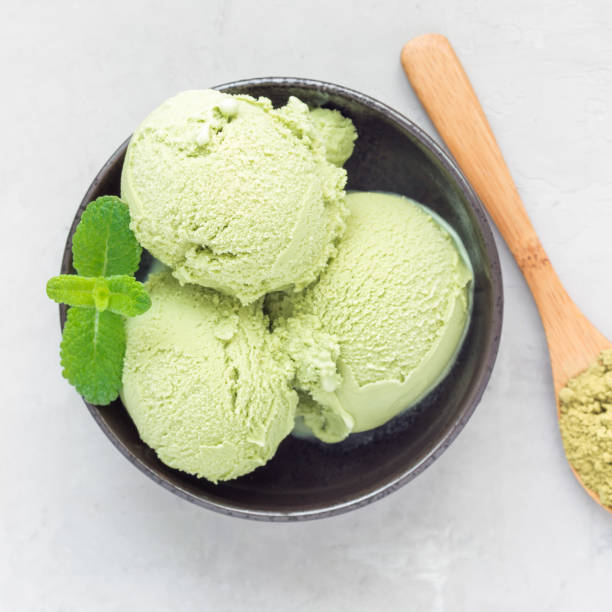 istock Matcha green tea ice cream balls in a black bowl, top view, square format 873212192