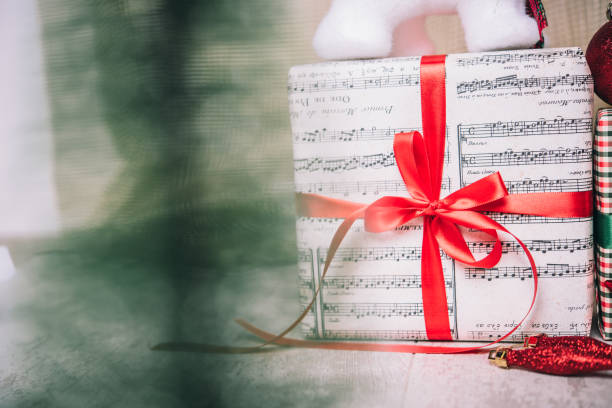 istock Close-up shot of a Christmas present behind Christmas tree 873219292