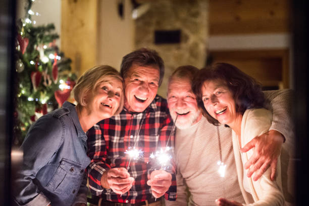 istock Senior friends with sparklers next to Christmas tree having fun. 873226828