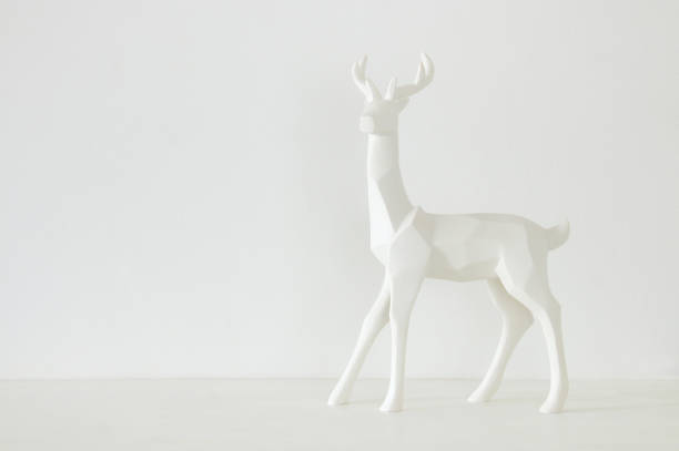 istock White reindeer on wooden table over white background 873230488