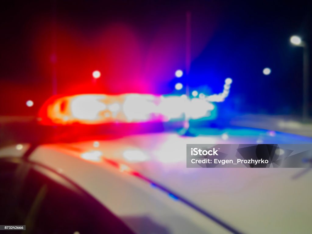 Red and blue Lights of police car in night time. Night patrolling the city. Abstract blurry image. Police Vehicle Lighting Stock Photo