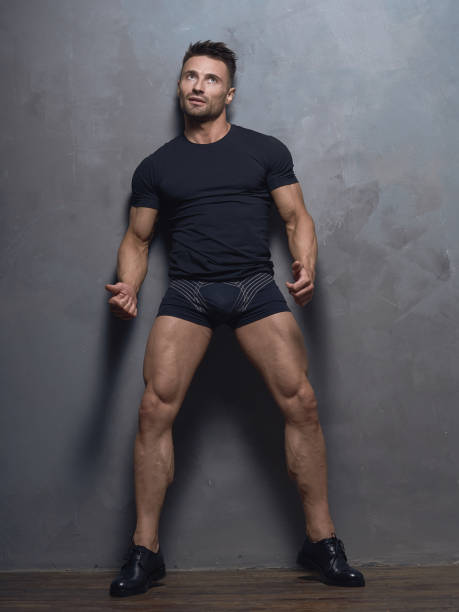 istock A brutal guy dressed in a dark tank top and shorts. 873246310
