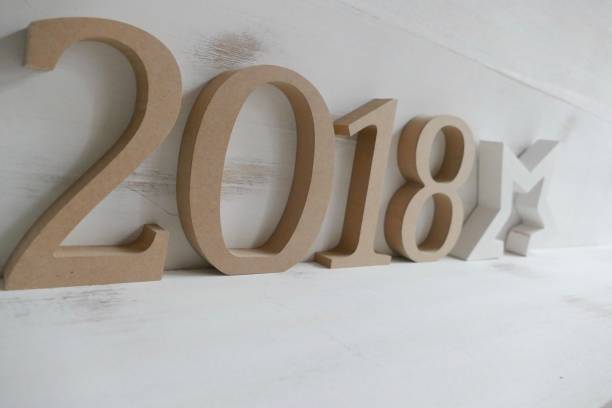 istock Numbers  2018 on white wooden wall with stars shape, new year 873249640