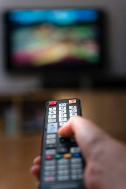 istock woman with television remote control changing channels 873256480