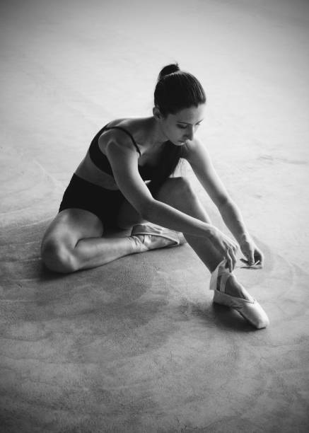 istock A female dancer tieing pointe shoes 873256722