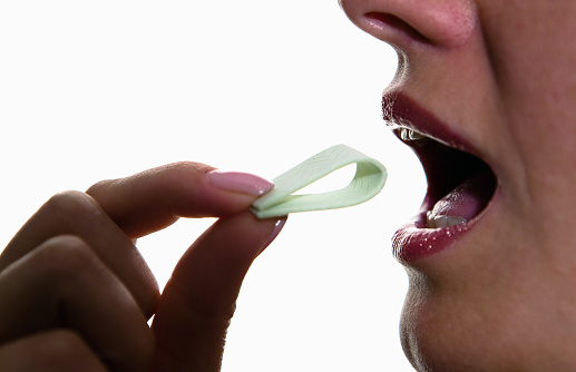 La chica pone la goma de mascar en su boca. photo