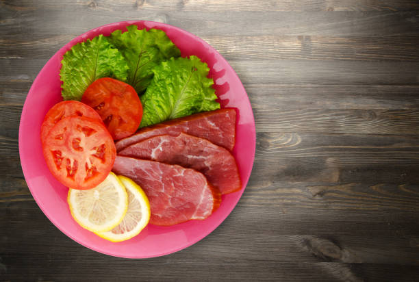 istock ham with salad, tomato and lemon on a plate. 873261802