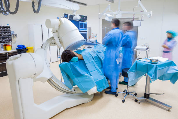 Surgery Non-invasive Scan C-arm X-ray Hospital Operation A non-invasive surgery in modern hospital while patient being scanned with C-arm X-ray. c arm fluoroscope stock pictures, royalty-free photos & images