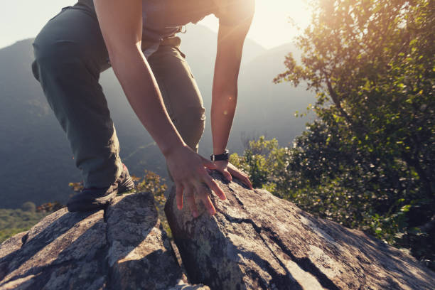 istock one woman hiker climbing rock on mountain top 873264158