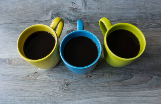 istock a three cup different color on the wooden gray background 873272344