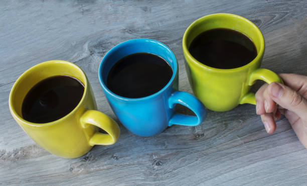 istock a three cup different color on the wooden gray background 873272364