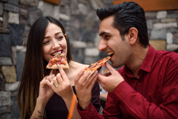 istock Young Couple Eating Slice of Pizza 873275492