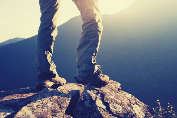 istock young woman hikers standing on cliff's edge in the sunrise 873278572
