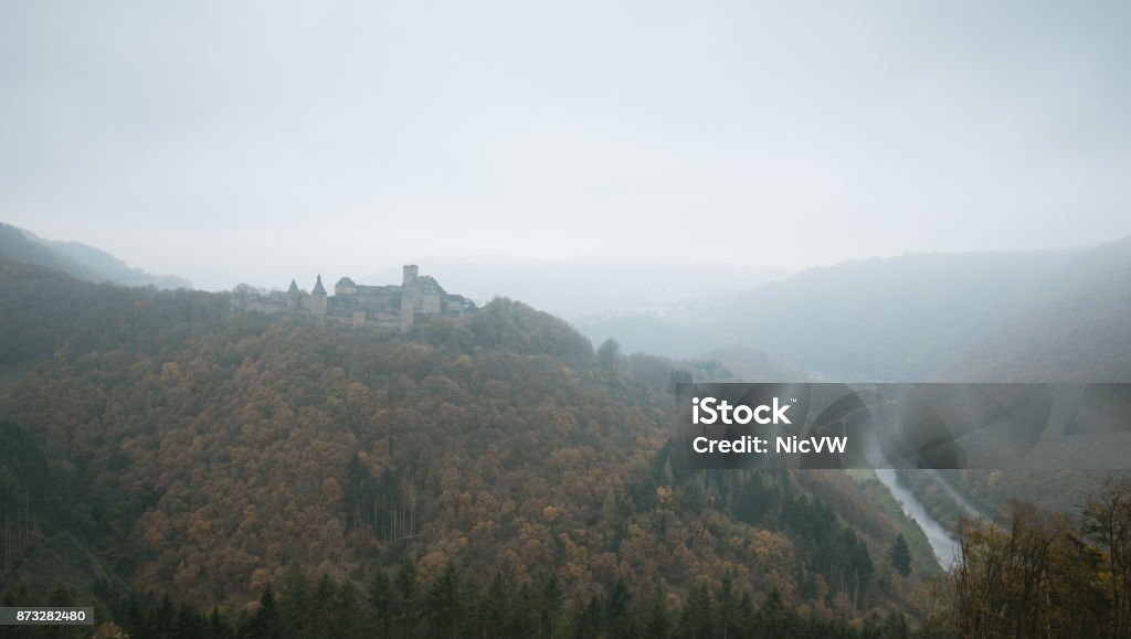 Bourscheid castle in the fog. Old fortress on a hill in Luxembourg. Autumn colors. Architecture Stock Photo