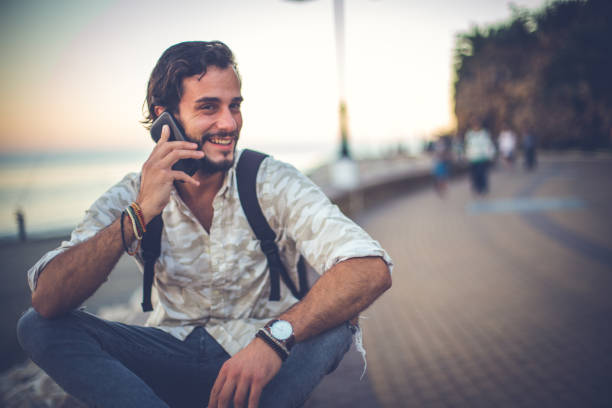 istock Bearded hipster with a backpack talking on the phone 873286452